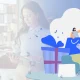 Woman in a bright office using a tablet, with a colorful, festive illustration of gifts and characters on the right side.